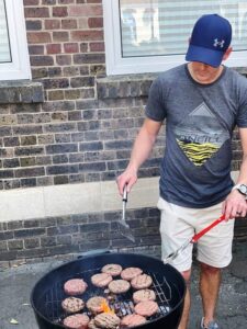 Burgers cooking on the barbecue outside church for the church building centenary event.