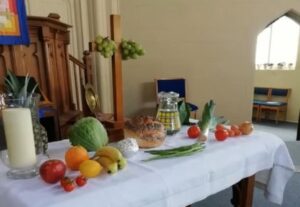 Harvest table set up at church for a previous service, with an assortment of fruits and vegetables.